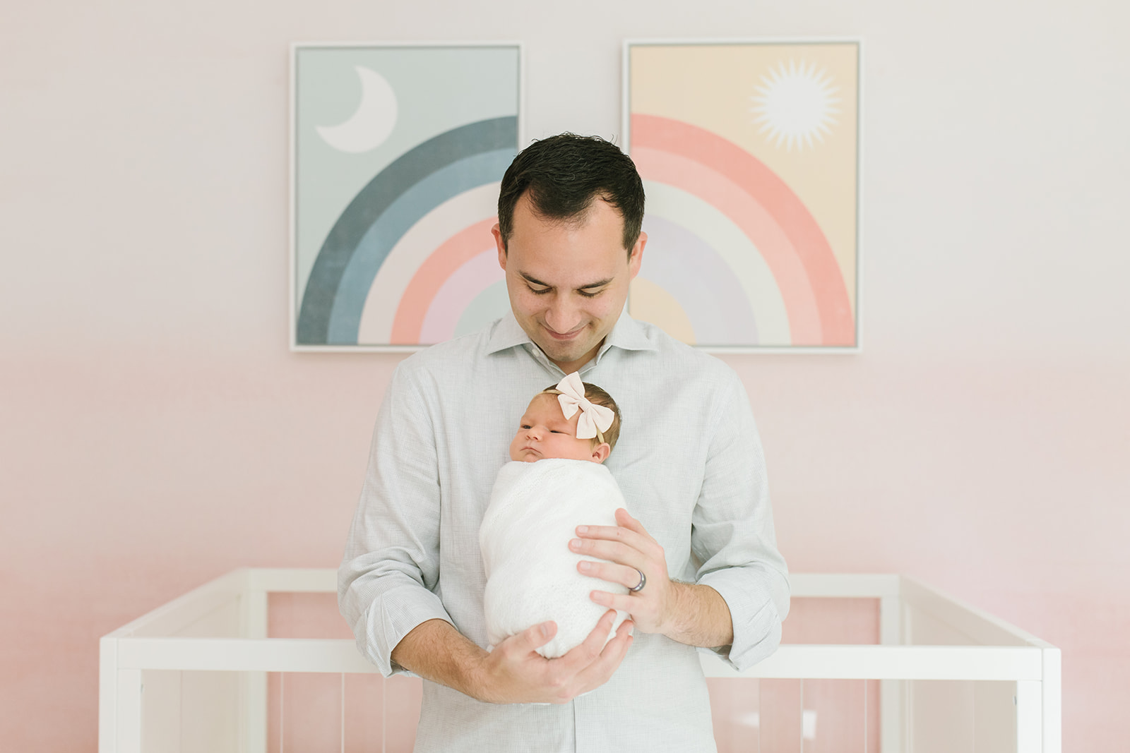 New dad holding his newborn girl in a white bow DC Baby Stores