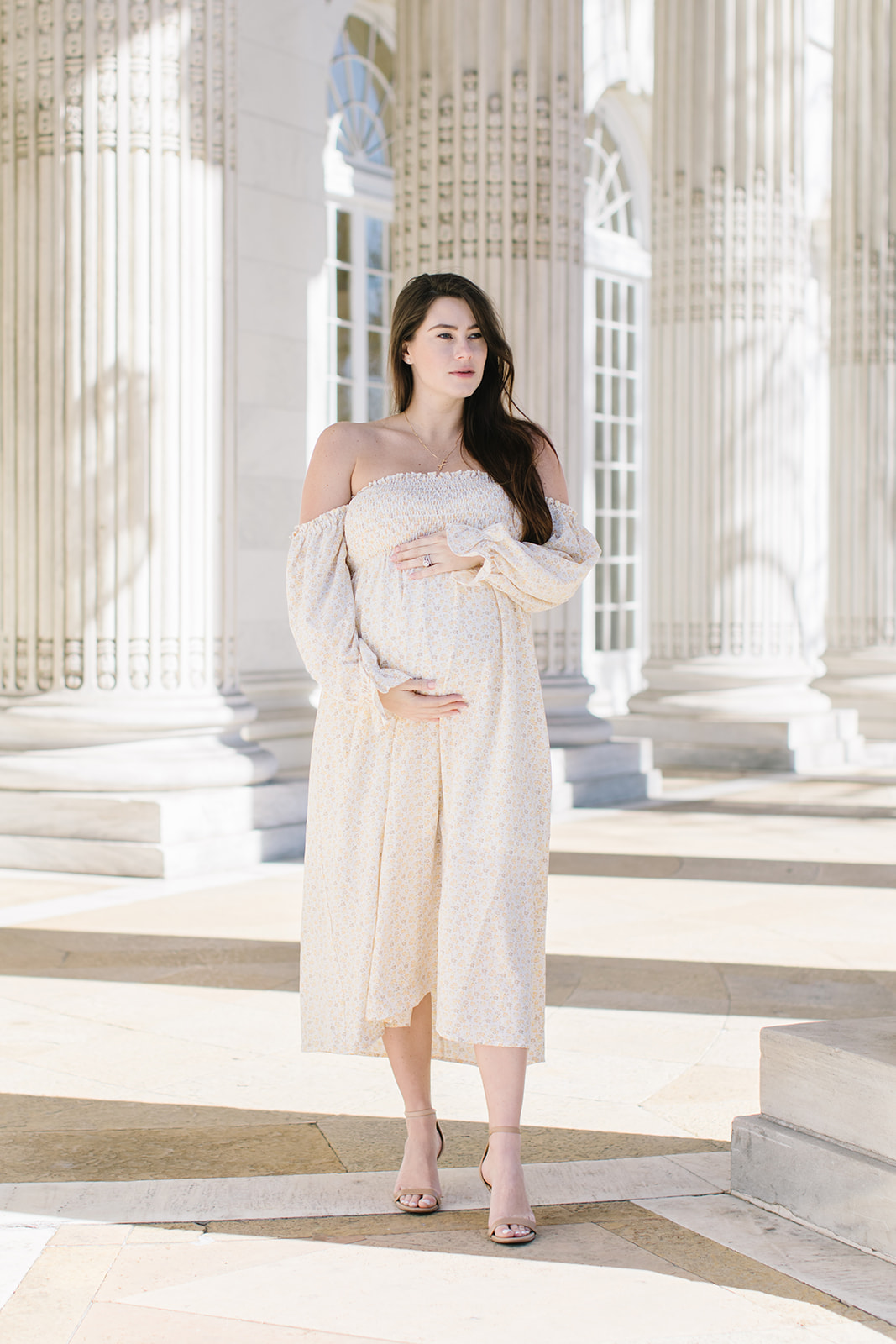 mom to be in white gown holding her belly Washington DC Prenatal Massage