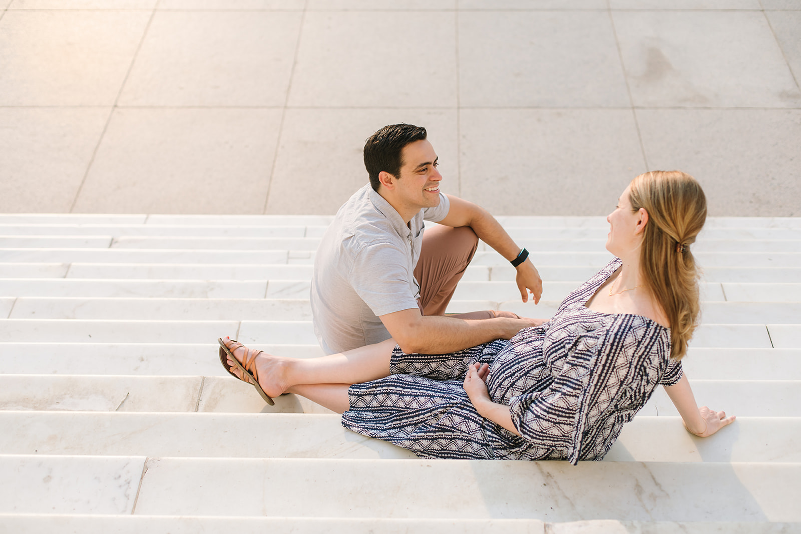 mom to be and partner sitting on stairs laughing during their Babymoon Near DC
