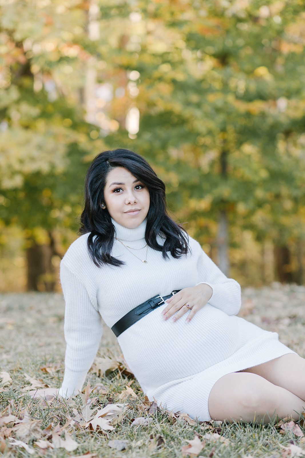 mom to be in a white maternity dress and black belt