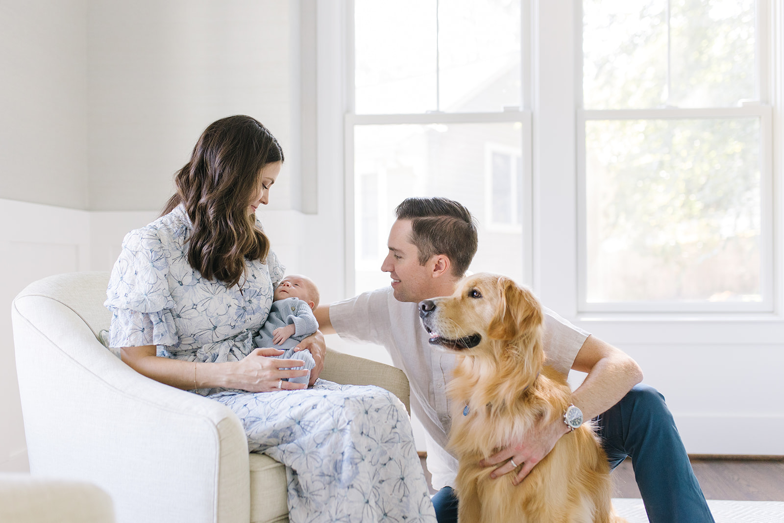 family of three sitting in the nursery with their dog night nurse dc