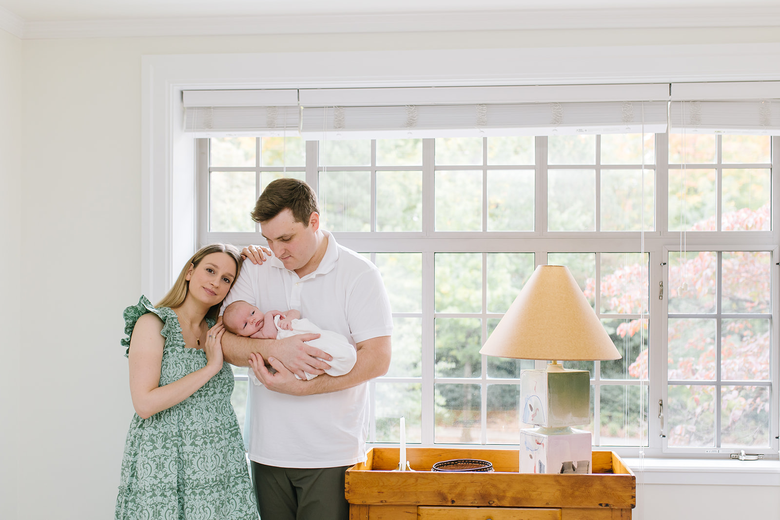 mother leans on her husband's shoulder while he holds their newborn child interior design washington dc