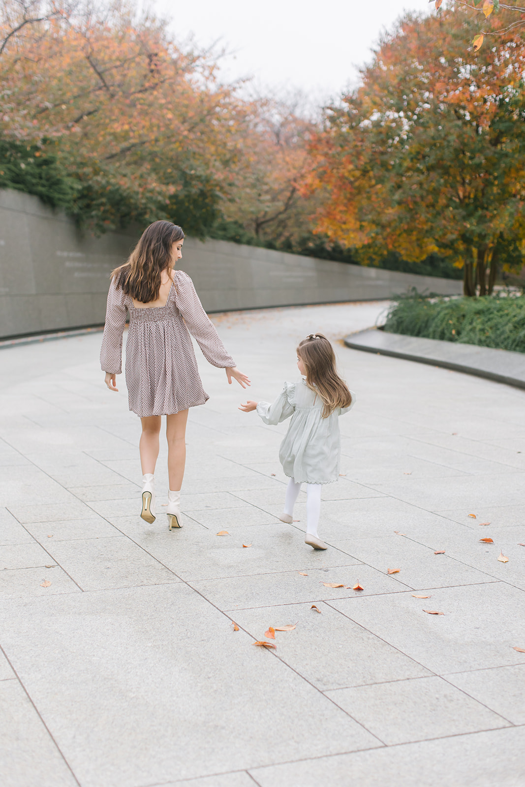 mom and daughter walk through the park in fall in dresses Mommy and me classes DC